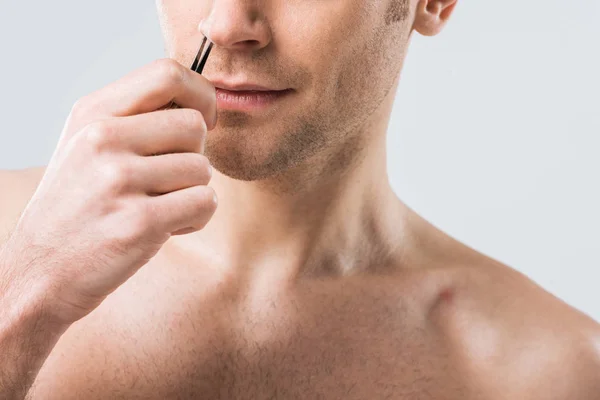 Abgeschnittene Ansicht eines Mannes, der Haare mit einer Pinzette aus der Nase zupft, isoliert auf grau — Stockfoto