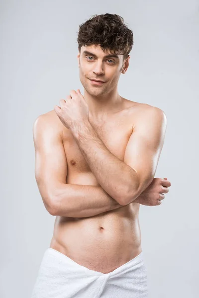 Handsome shirtless smiling man in towel isolated on grey — Stock Photo