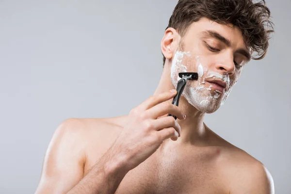 Handsome caucasian man foam on face shaving with razor, isolated on grey — Stock Photo