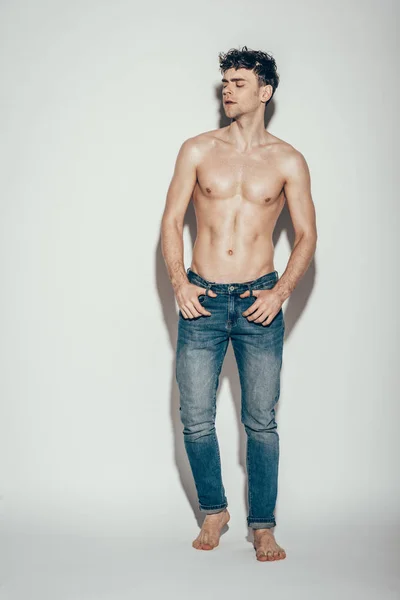 Sexy torse nu bel homme en jeans posant sur gris — Photo de stock