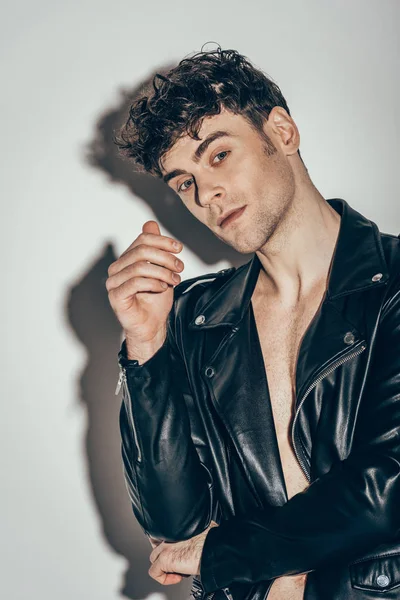 Bonito sexy rocker posando no preto jaqueta de couro no cinza — Fotografia de Stock