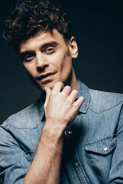 Handsome thoughtful man posing in denim shot isolated on dark grey — Stock Photo