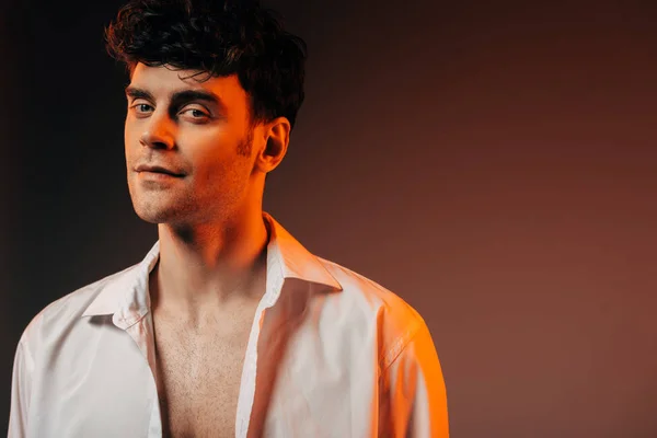 Elegante bonito homem posando em camisa branca, isolado em marrom — Fotografia de Stock