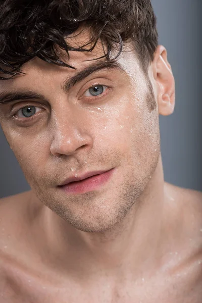 Young man with wet face, isolated on grey — Stock Photo