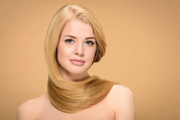 Affascinante giovane donna con i capelli biondi lucidi guardando la fotocamera — Foto stock