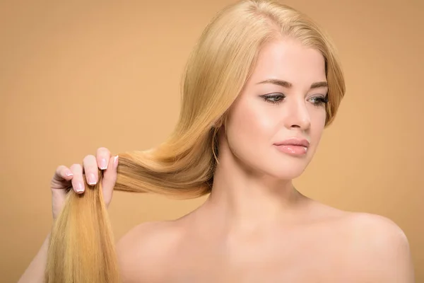 Femme blonde nue toucher les cheveux raides et détourner les yeux — Photo de stock