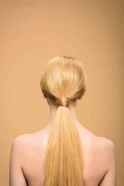 Vue arrière de fille blonde nue avec de longs cheveux raides isolés sur beige — Photo de stock