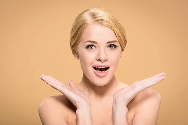 Surpris jeune femme nue souriant à la caméra isolé sur beige — Photo de stock