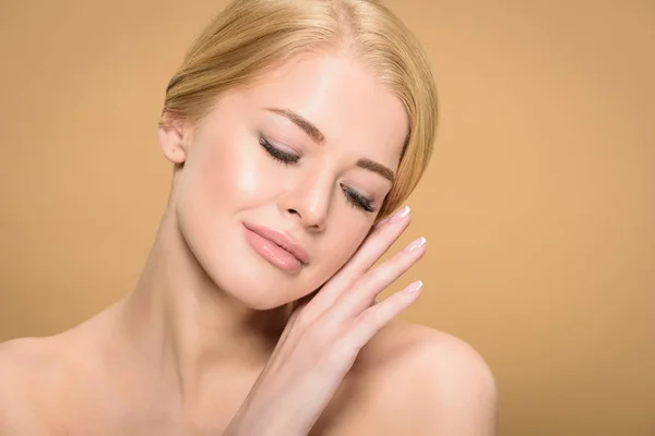 Beautiful tender naked girl touching face with hand isolated on beige — Stock Photo