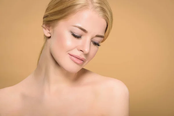 Schöne lächelnde nackte blonde Mädchen, die isoliert auf beige herunterschaut — Stockfoto