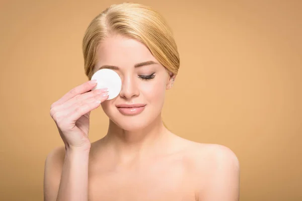 Schöne lächelnde nackte Mädchen mit Baumwollscheibe isoliert auf beige — Stockfoto