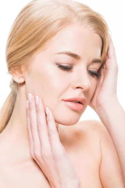 Close-up view of beautiful tender blonde girl touching face and looking down isolated on white — Stock Photo