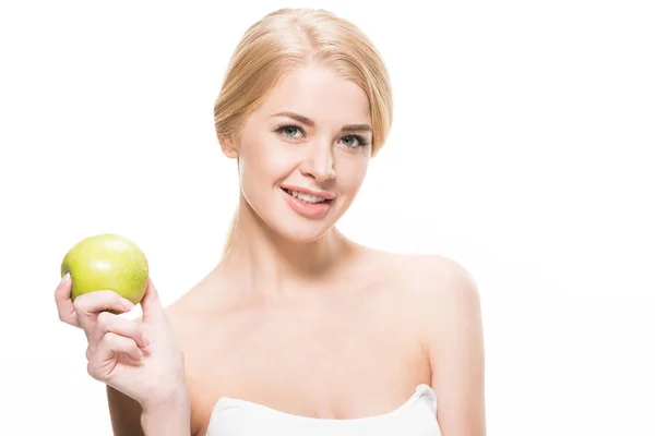 Красива щаслива блондинка тримає свіже яблуко і посміхається на камеру ізольовано на білому — стокове фото