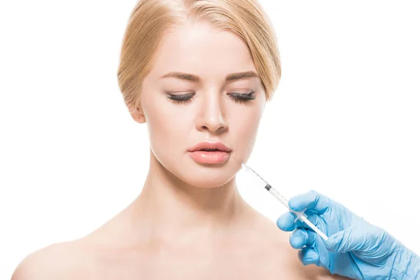 Beautiful naked woman receiving beauty injection in face and looking down isolated on white — Stock Photo