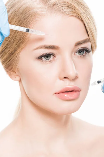 Abgeschnittene Aufnahme eines Kosmetikers, der attraktiven jungen Frau Schönheitsinjektionen macht, isoliert auf Weiß — Stockfoto