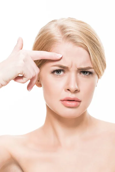 Unhappy naked woman pointing at wrinkles on forehead and looking at camera isolated on white — Stock Photo