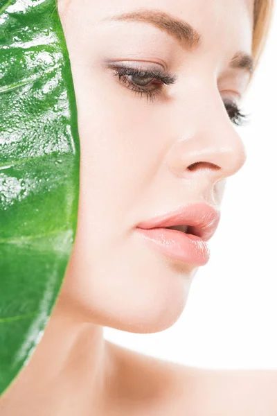 Крупним планом красива ніжна молода жінка з зеленим тропічним листом ізольована на білому — стокове фото