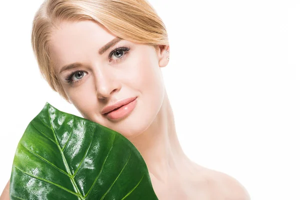 Beautiful naked girl with fresh green leaf smiling at camera isolated on white — Stock Photo