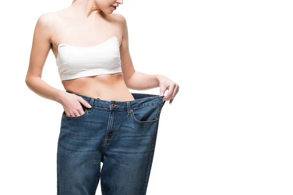 Cropped shot of slim young woman wearing oversized jeans isolated on white — Stock Photo