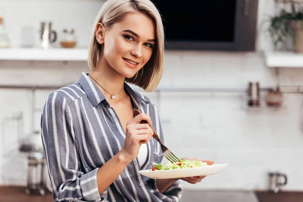 Selective focus of attractive woman holding and looking at camera — Stock Photo