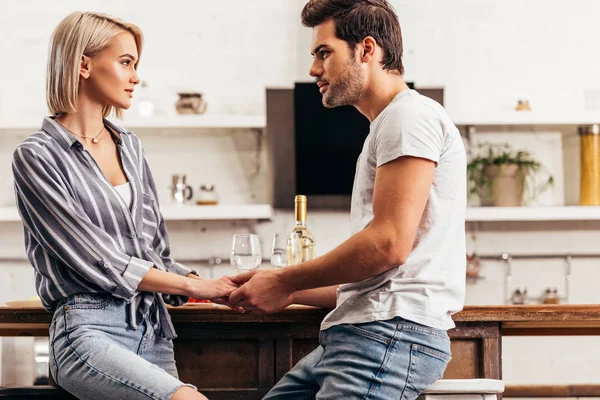 Attraente fidanzata e bello fidanzato tenendosi per mano e parlando — Foto stock