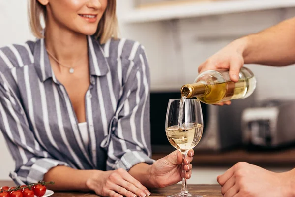 Vista ritagliata di fidanzato versando vino per la fidanzata attraente — Foto stock