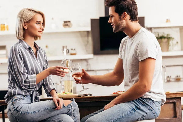 Handsome boyfriend and attractive girlfriend holding wine glasses — Stock Photo