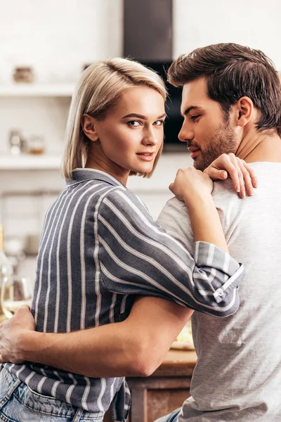 Handsome boyfriend and attractive girlfriend hugging and looking at camera — Stock Photo