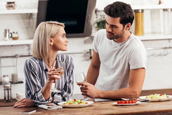 Handsome boyfriend and attractive girlfriend holding wine glasses — Stock Photo