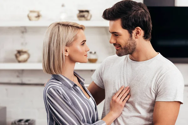 Enfoque selectivo de novio guapo y novia atractiva abrazando y hablando - foto de stock