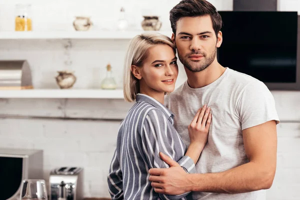 Schöner Freund und attraktive Freundin, die sich umarmt und in die Kamera schaut — Stockfoto