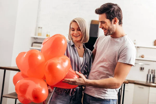 Handsome boyfriend greeting attractive girlfriend on Valentines day — Stock Photo