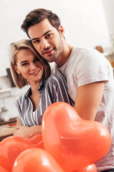 Selective focus of handsome boyfriend hugging and greeting attractive girlfriend on Valentine's day — Stock Photo