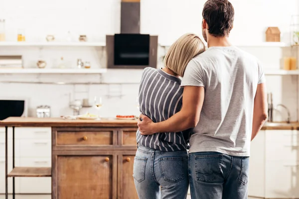 Enfoque selectivo de novio y novia abrazando y de pie en la cocina - foto de stock