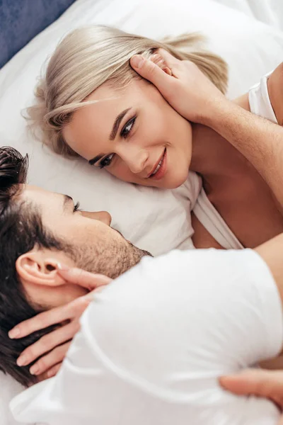 Attrayant petite amie et beau petit ami souriant et couché au lit — Photo de stock
