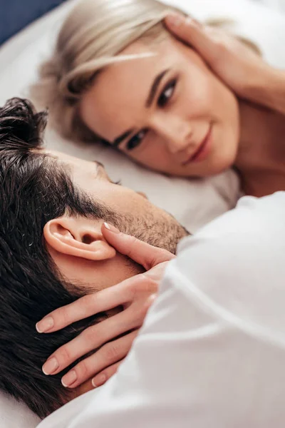 Attractive girlfriend and handsome boyfriend smiling and laying in bed — Stock Photo