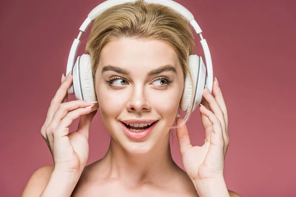 Chica feliz escuchando música con auriculares, aislado en rosa - foto de stock