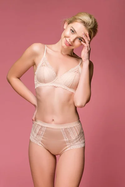 Bela menina feliz posando em lingerie, isolado em rosa — Fotografia de Stock