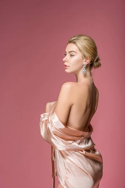 Bela jovem posando em roupão de seda elegante, isolado em rosa — Fotografia de Stock