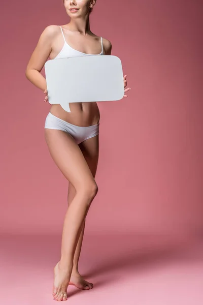 Vista cortada de jovem mulher em roupa interior branca posando com bolha de fala, em rosa — Fotografia de Stock