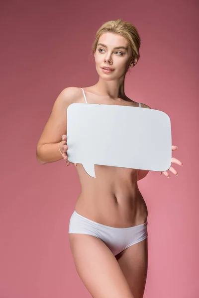 Attractive young woman in white underwear posing with speech bubble, isolated on pink — Stock Photo