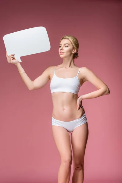 Beautiful girl in white underwear posing with speech bubble, isolated on pink — Stock Photo