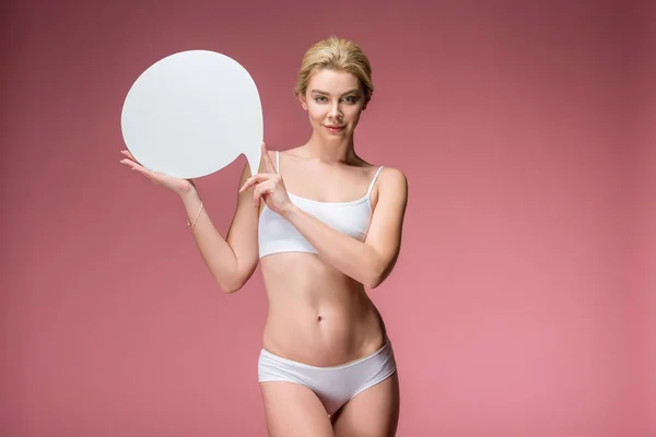 Beautiful young woman in white underwear posing with speech bubble, isolated on pink — Stock Photo