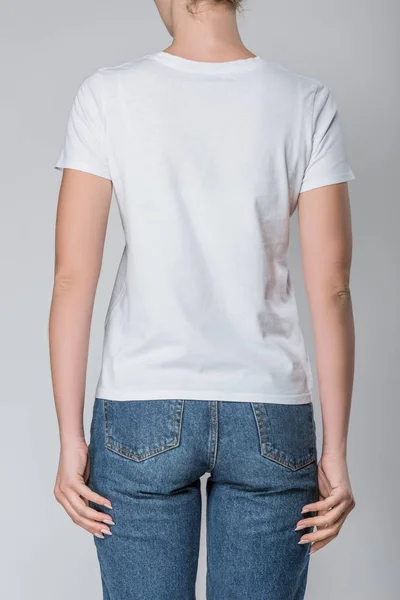 Vue arrière de la femme posant en t-shirt blanc avec espace de copie, isolé sur gris — Photo de stock
