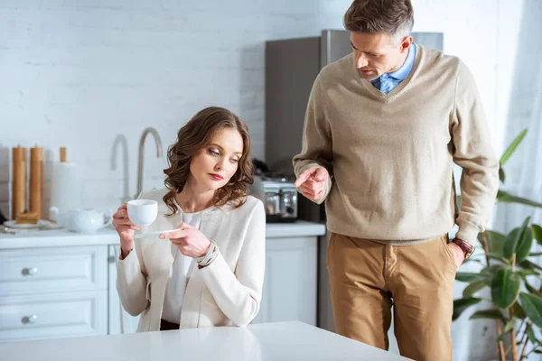 Pareja de adultos discutiendo durante el desayuno por la mañana - foto de stock