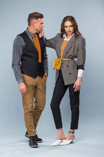Красива стильна пара в офіційному одязі позує на сірому фоні — стокове фото