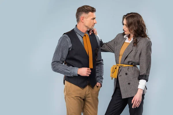 Schönes stylisches Paar, das sich gegenseitig ansieht und isoliert auf grau posiert — Stockfoto