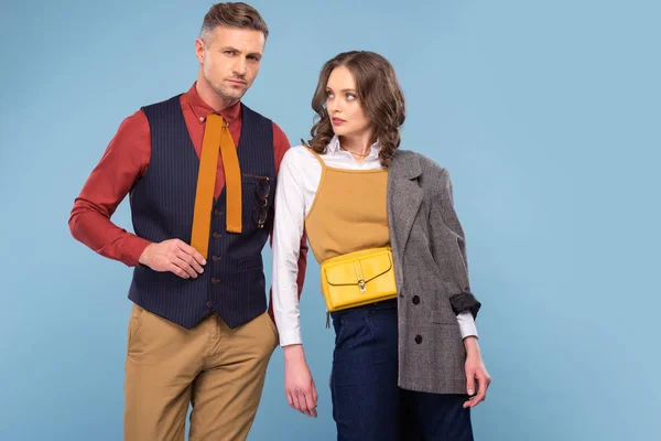 Atractivo elegante pareja en formal desgaste posando aislado en azul - foto de stock