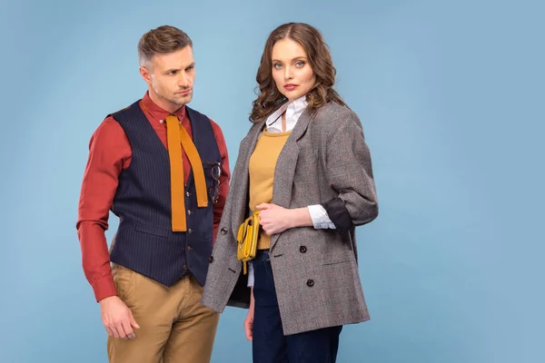 Attractive fashionable couple in formal wear posing isolated on blue — Stock Photo