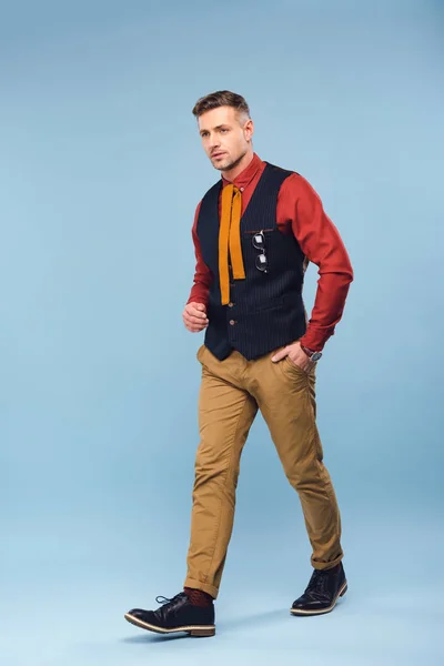 Hombre con estilo de confianza en el desgaste formal mirando a la cámara en el fondo azul - foto de stock